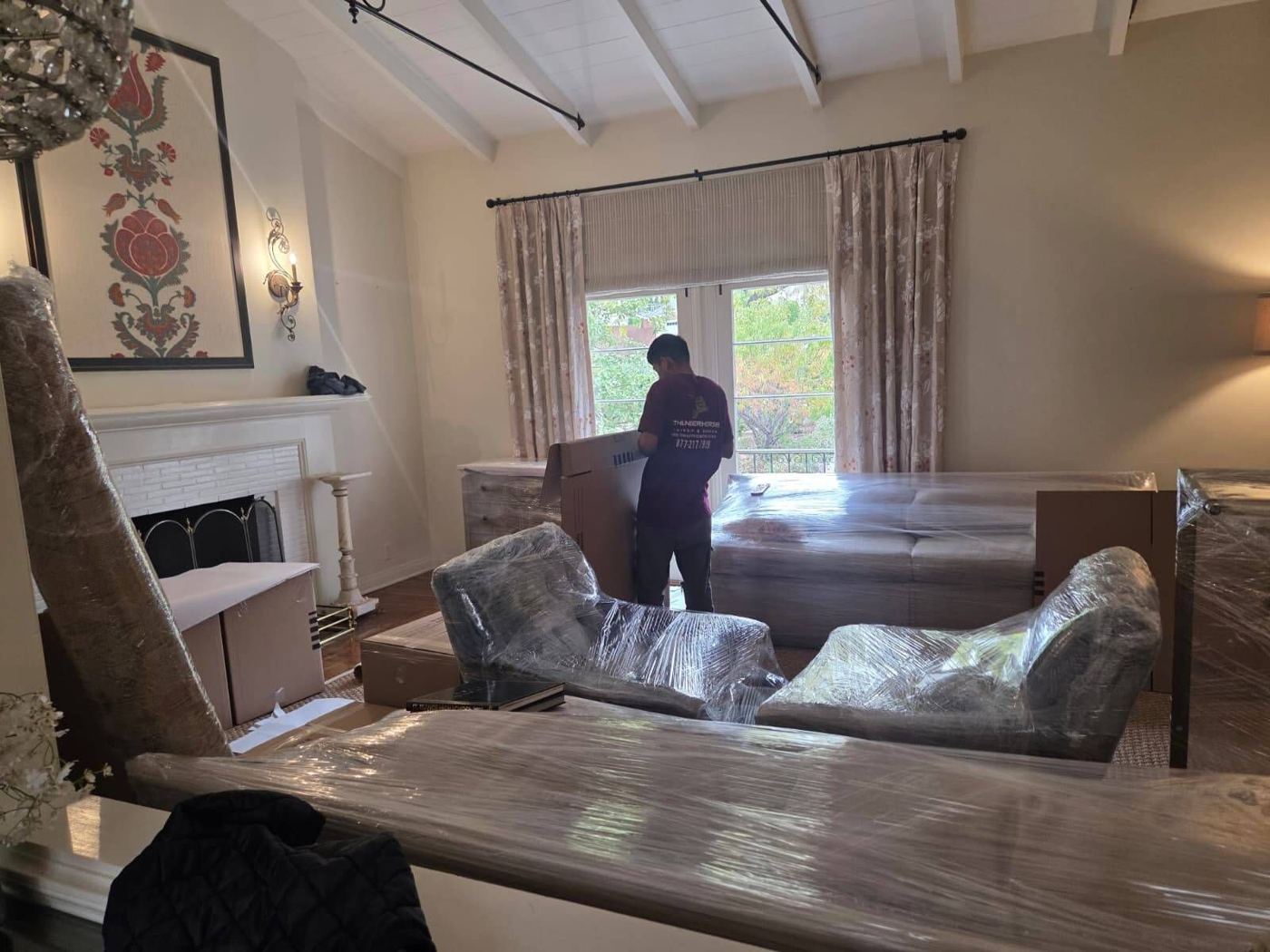 Mover wrapping fine furniture with protective padding.