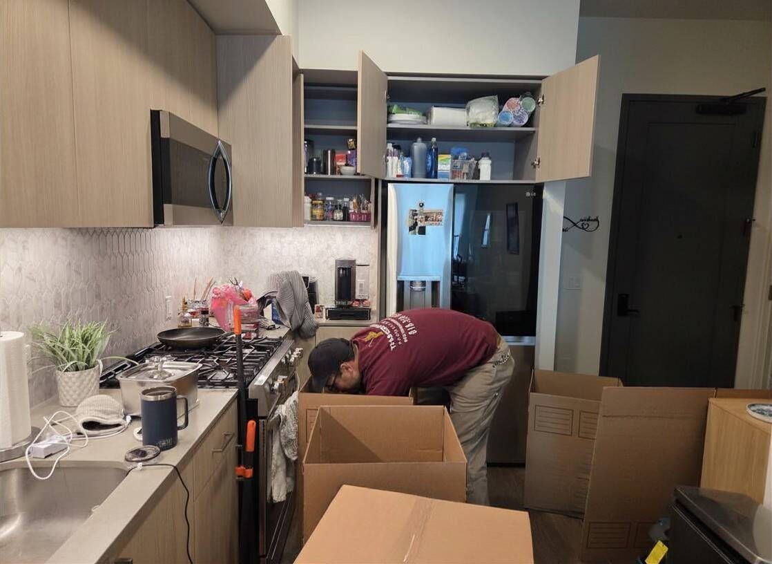Mover packing kitchen items into boxes.
