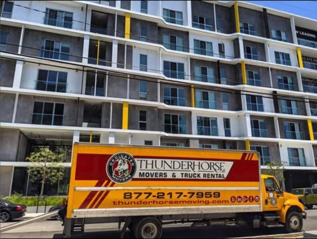 Thunderhorse moving truck in front of an apartment building.