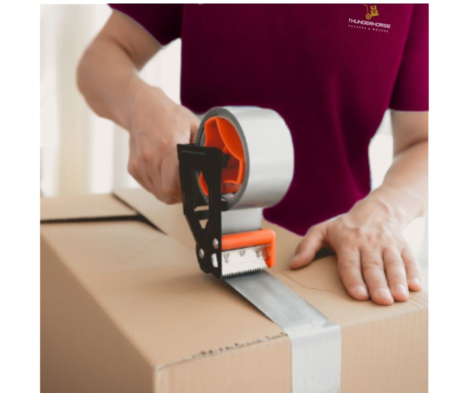 Mover taping a packed box.